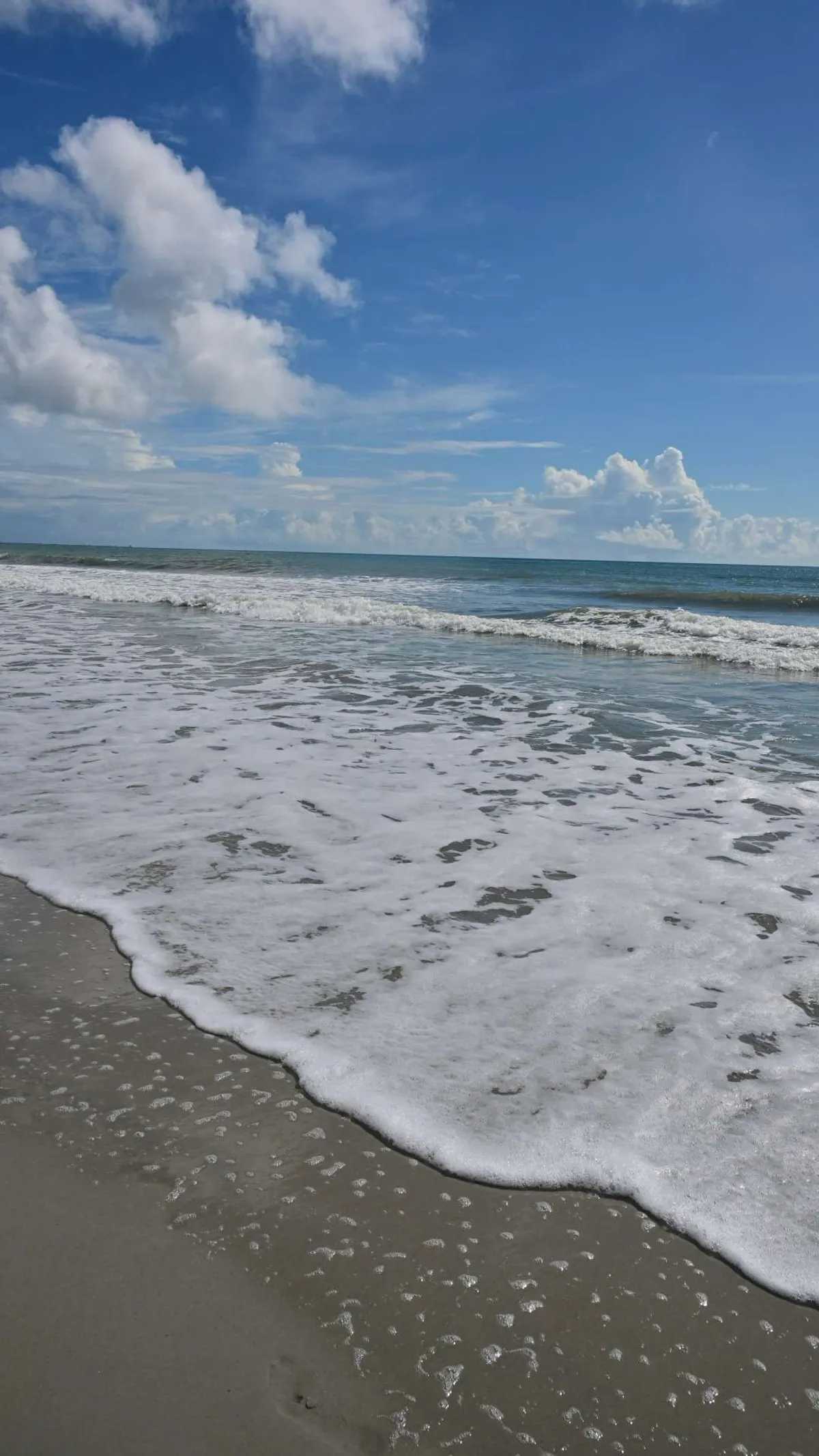 Wide open beach under a tall Florida sky