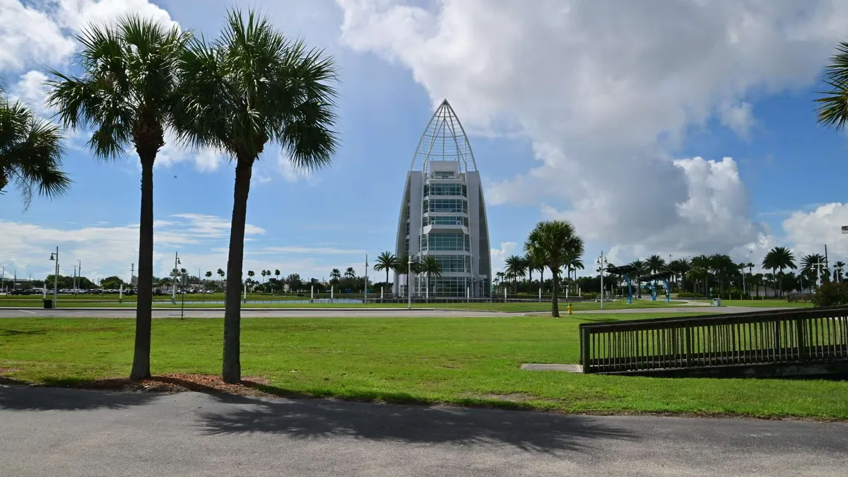 Palms and launch-country architecture under cumulus clouds
