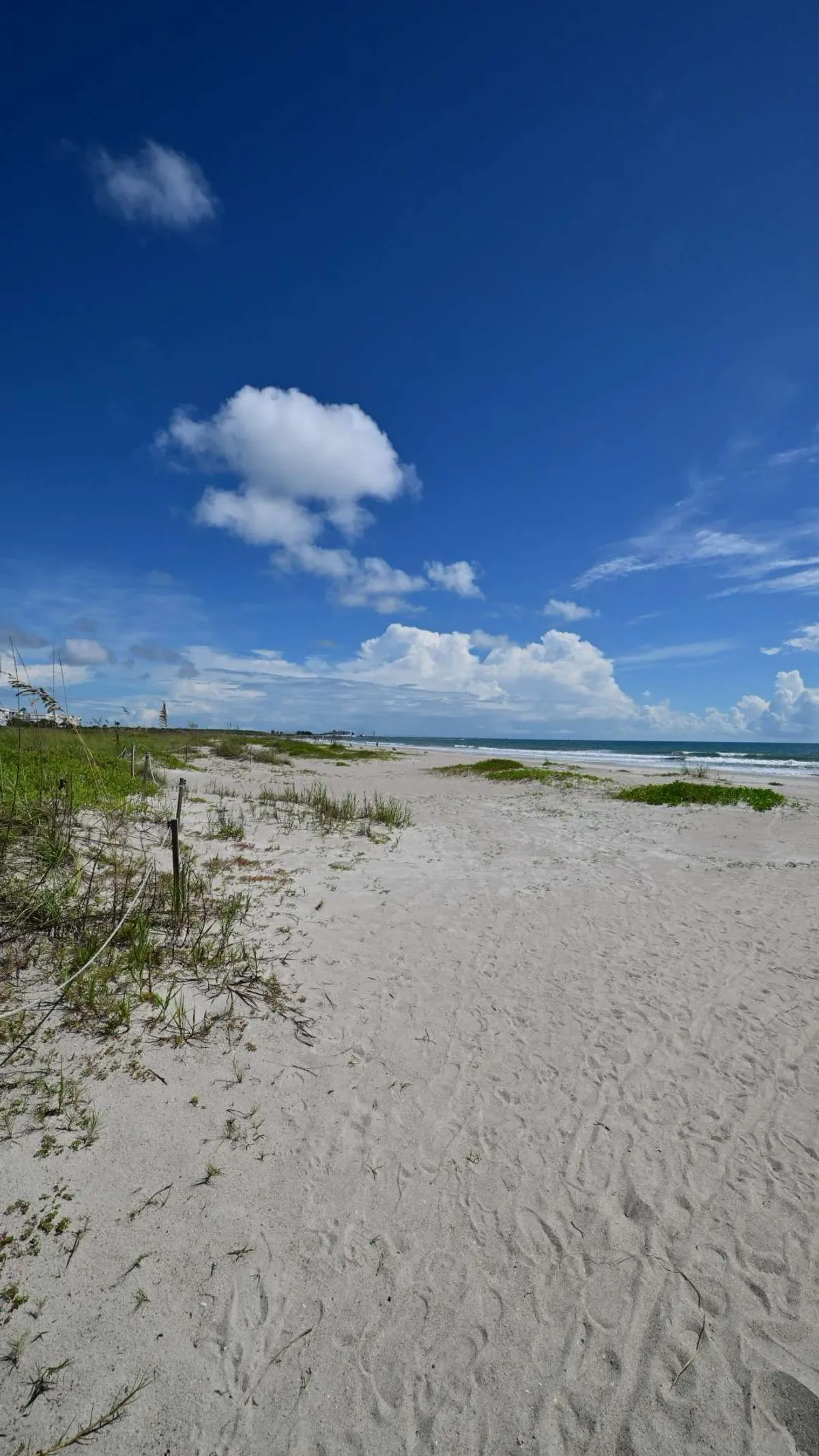 The wide beach at low sun, clouds stacked over the horizon